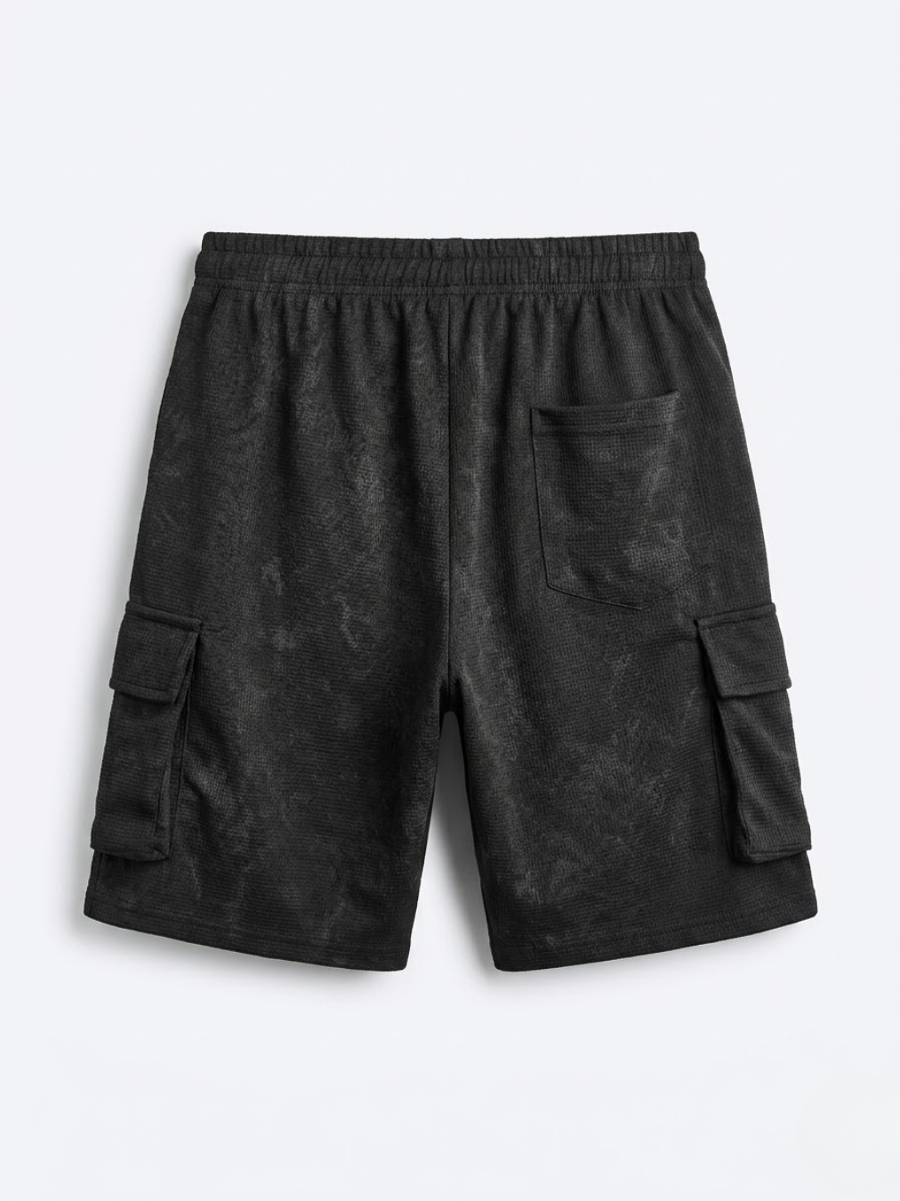 Vista trasera del pantalón corto negro del conjunto que detalla el quinto bolsillo trasero de parche y el corte holgado.