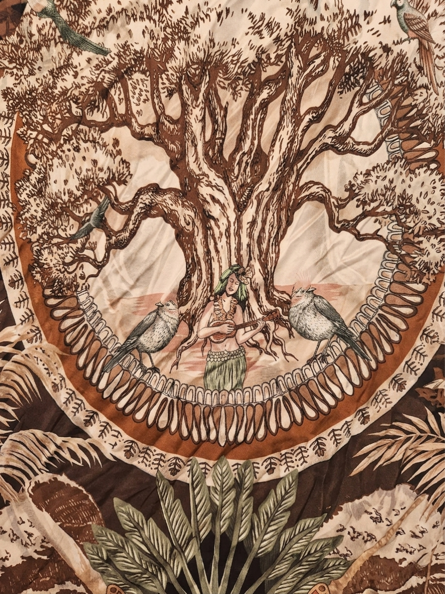 Detalle del estampado central con diseño de árbol de la vida y aves exóticas.