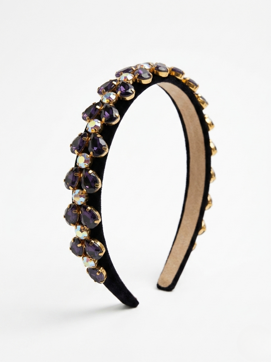 Diadema de terciopelo negro con pedrería en forma de lágrima color morado amatista y detalles dorados de Angel Salvaje.