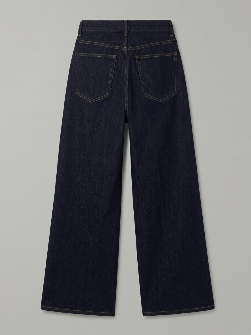 Vista posterior de los pantalones denim oscuros resaltando el brillo de los cristales y el ajuste de los bolsillos.