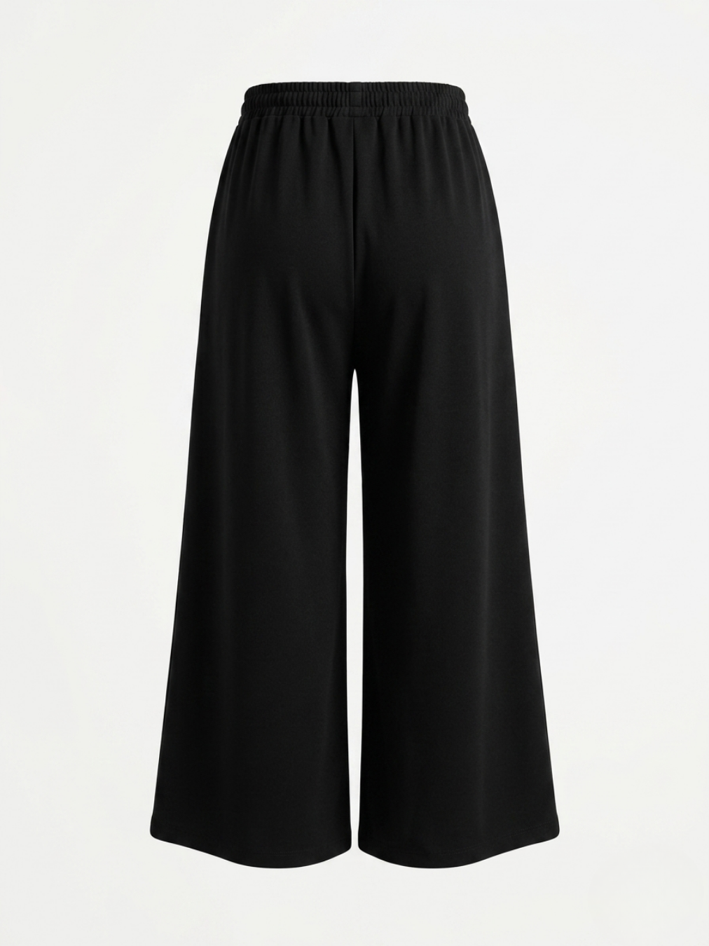 Detalle de la espalda del pantalón fluido negro resaltando el corte holgado y adaptable.