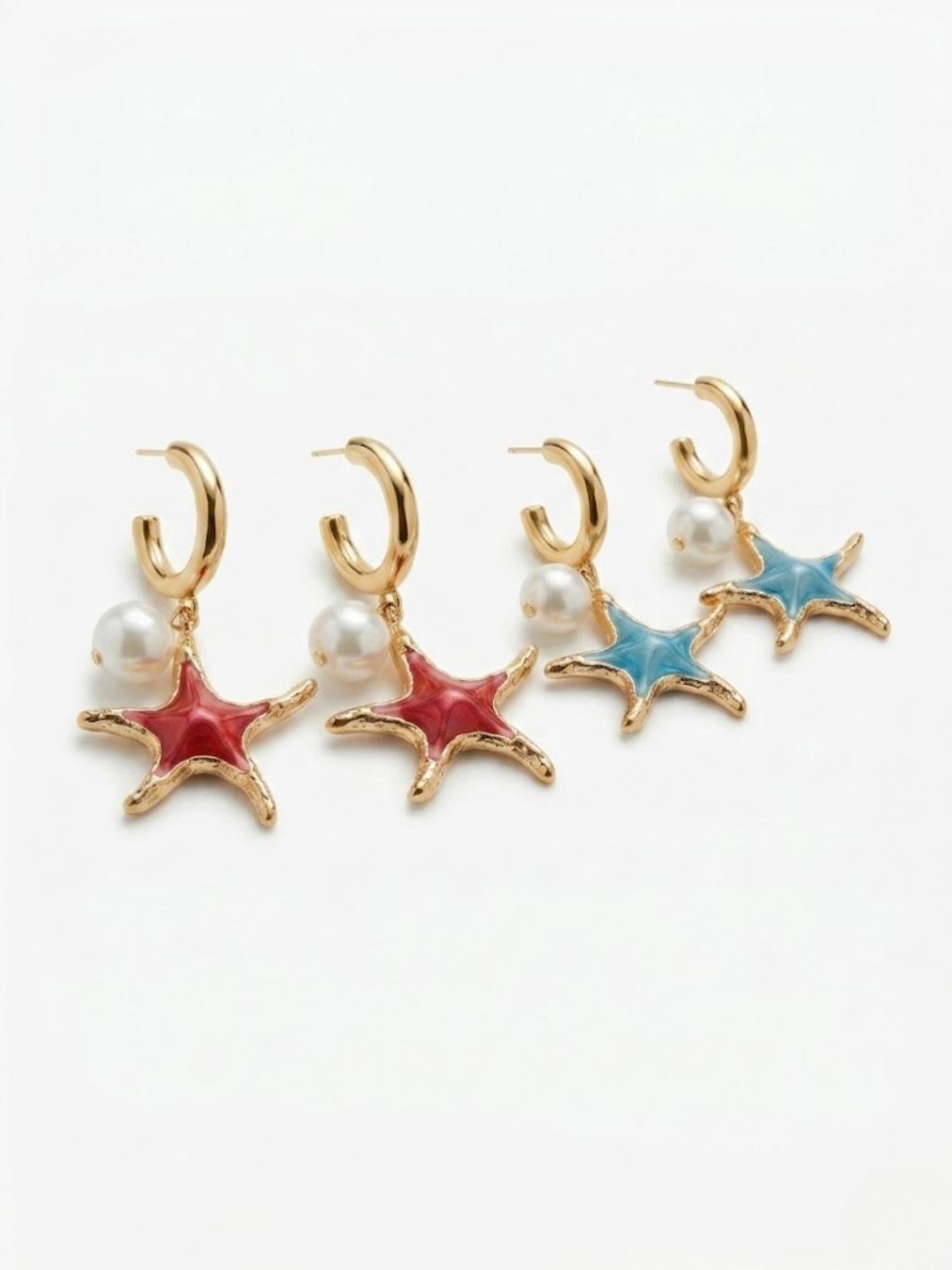 Muestra de las dos variantes de pendientes de aro dorados con colgantes de perla y estrella de mar esmaltada en colores rojo coral y azul celeste de Ángel Salvaje.