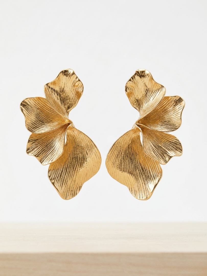Pendientes dorados grandes con forma de pétalos orgánicos y acabado con textura lineal de la tienda Angel Salvaje.