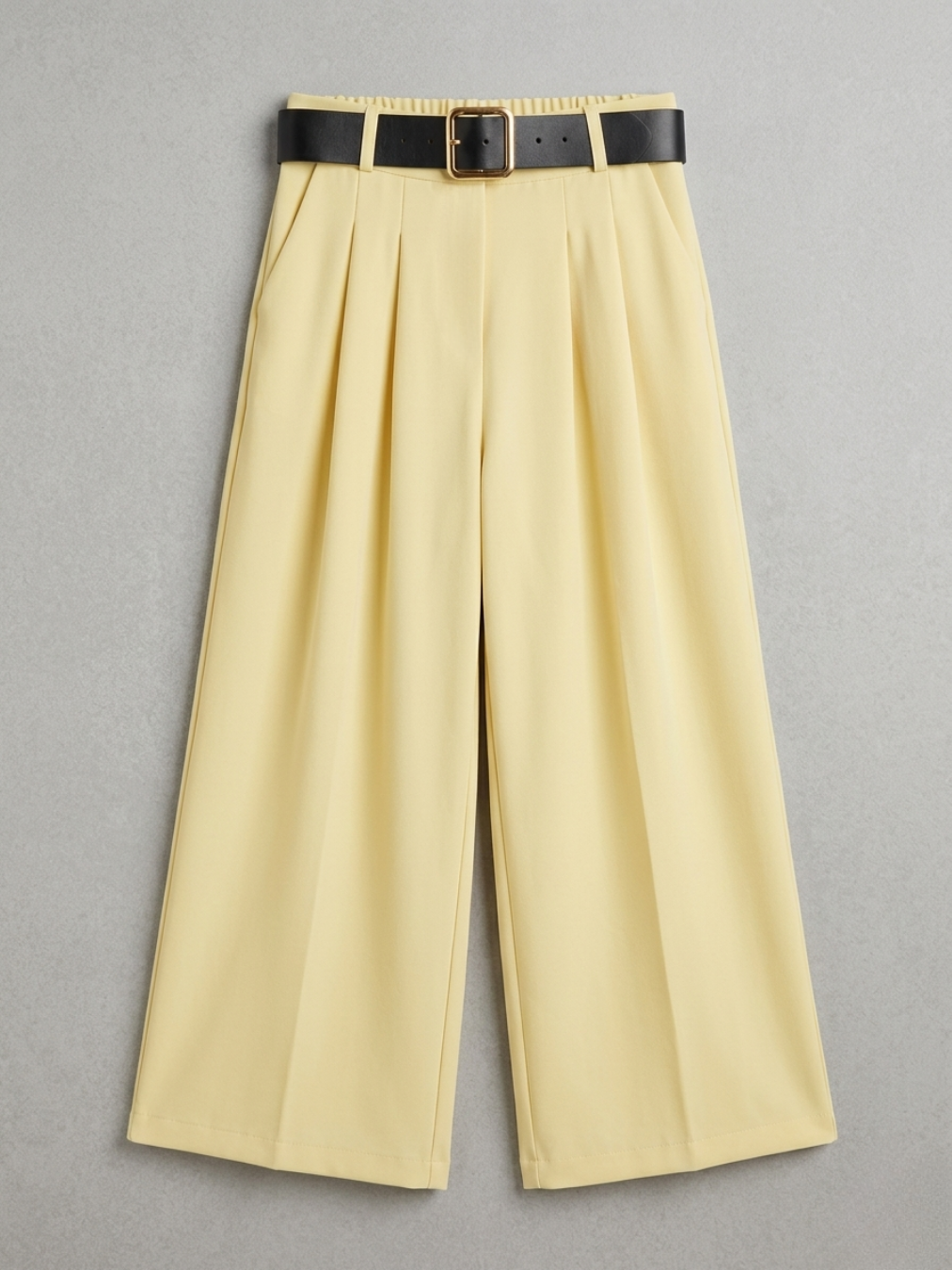 Pantalón Wide Leg amarillo pastel con bolsillos laterales y cinturón negro con hebilla dorada.