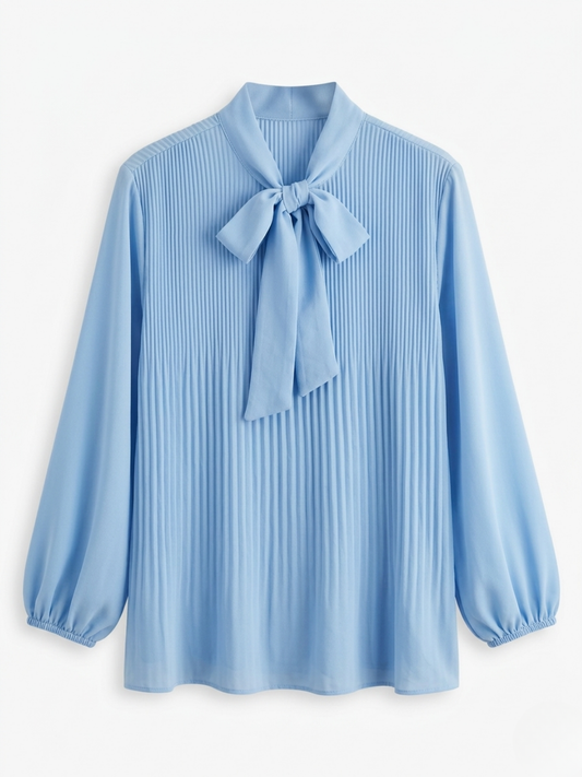 Blusa romántica plisada en color azul bebé con detalle de lazo frontal.
