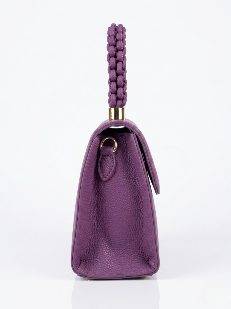 Perspectiva de perfil del bolso morado orquídea mostrando el fuelle lateral y los enganches metálicos.