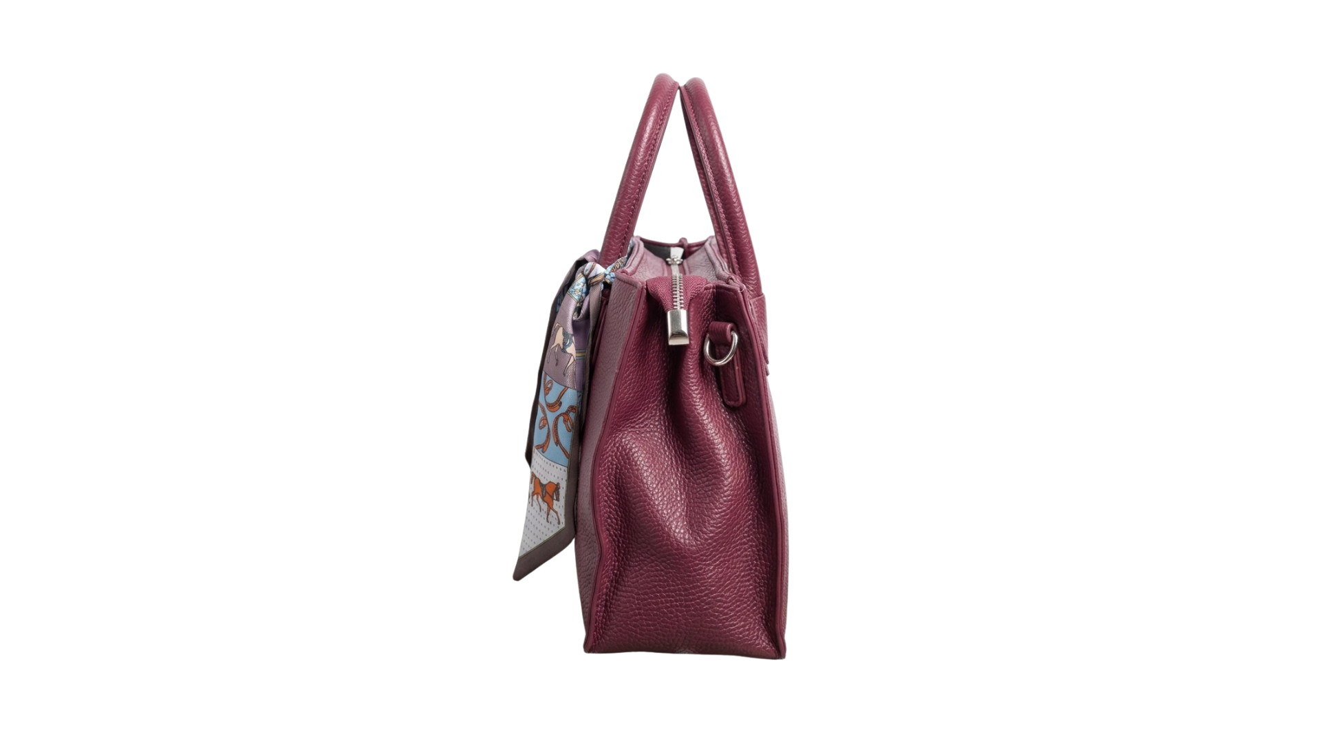 Vista lateral del bolso color vino borgoña o burdeos de polipiel deluxe colgado con su correa de mano.