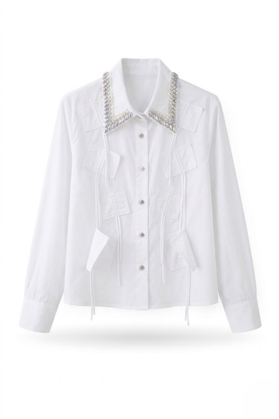 Vista frontal de la camisa blanca de algodón con cuello decorado con perlas y cristales.
