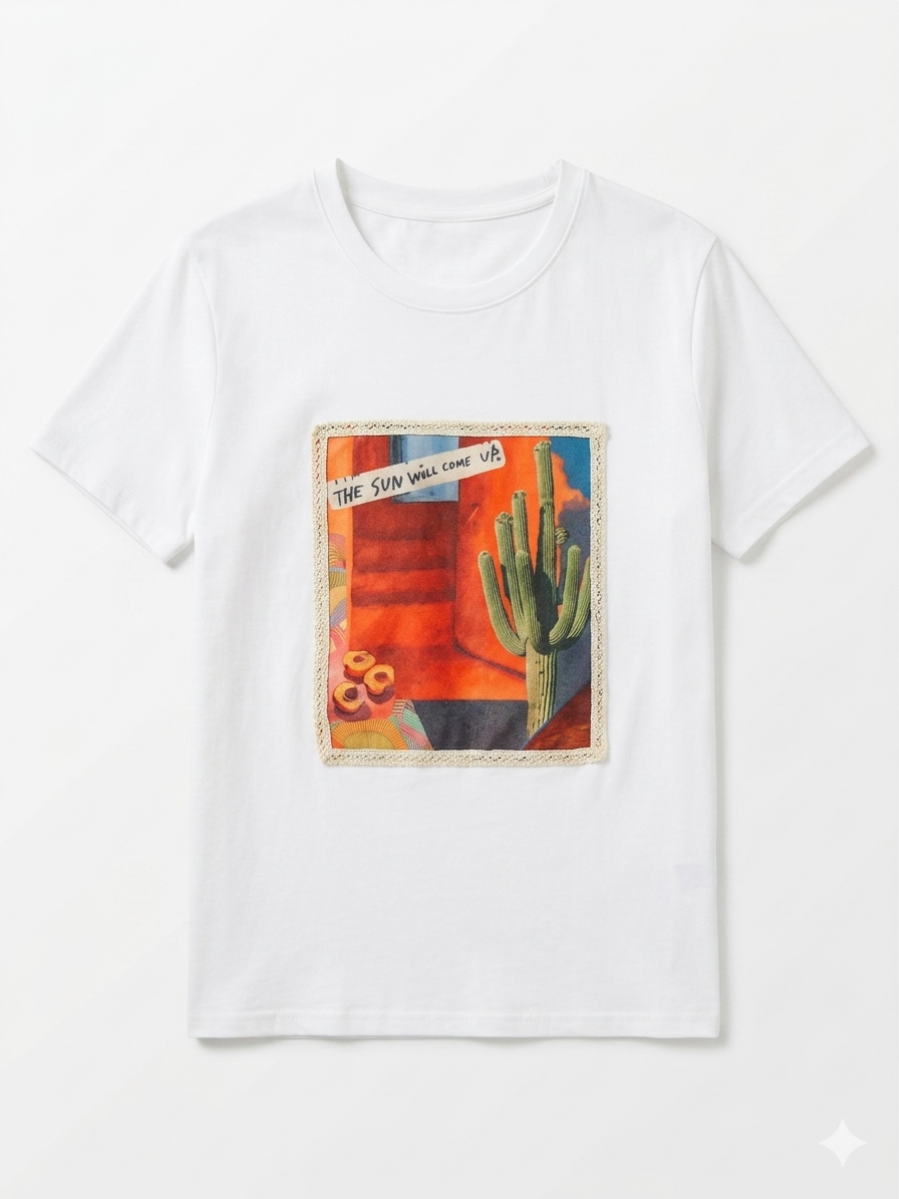 Camiseta de algodón blanca con parche central de diseño desértico y mensaje positivo.
