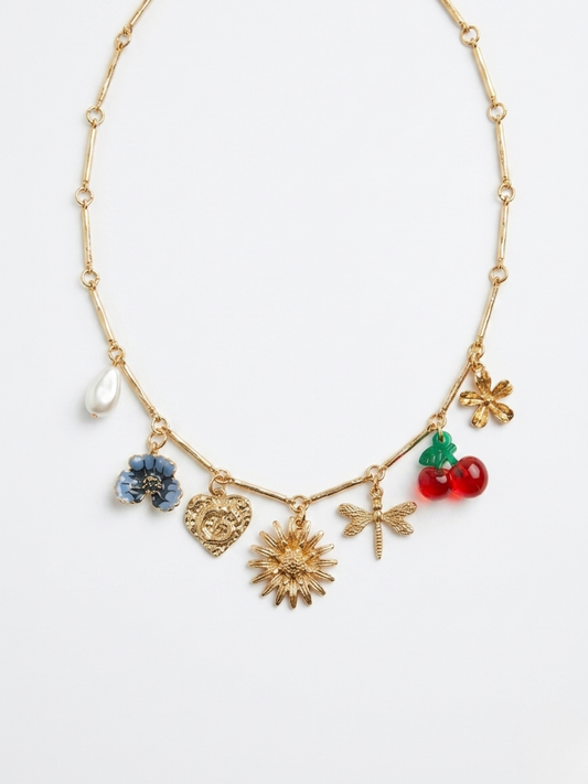 Vista frontal de collar gargantilla dorado con múltiples amuletos colgantes de libélula, sol, flores, corazón y cerezas esmaltadas de Angel Salvaje.