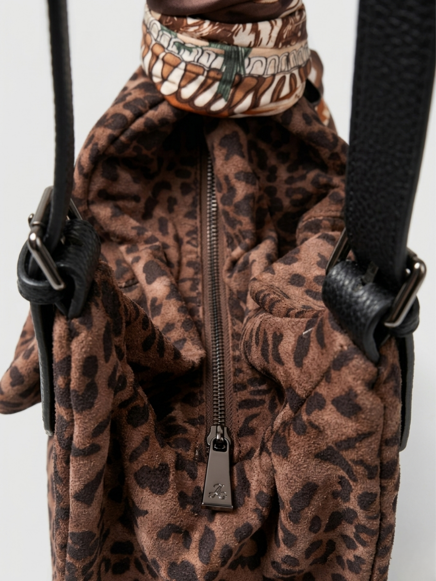 Primer plano de la cremallera y la textura suave del bolso animal print.