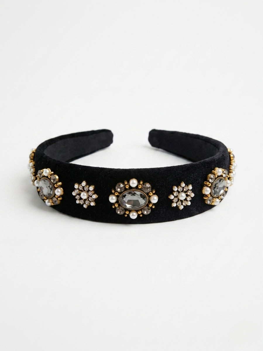 Diadema acolchada de terciopelo negro con aplicaciones de medallones dorados, perlas y cristales de Angel Salvaje.