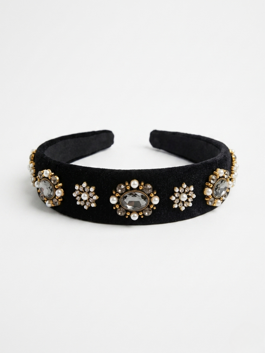 Diadema acolchada de terciopelo negro con aplicaciones de medallones dorados, perlas y cristales de Angel Salvaje.