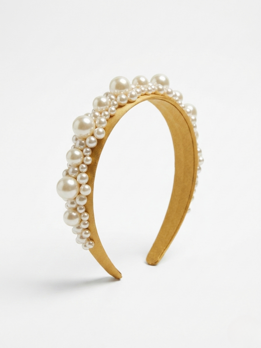 Diadema de satén en color mostaza dorado decorada con perlas blancas de varios tamaños de Angel Salvaje.