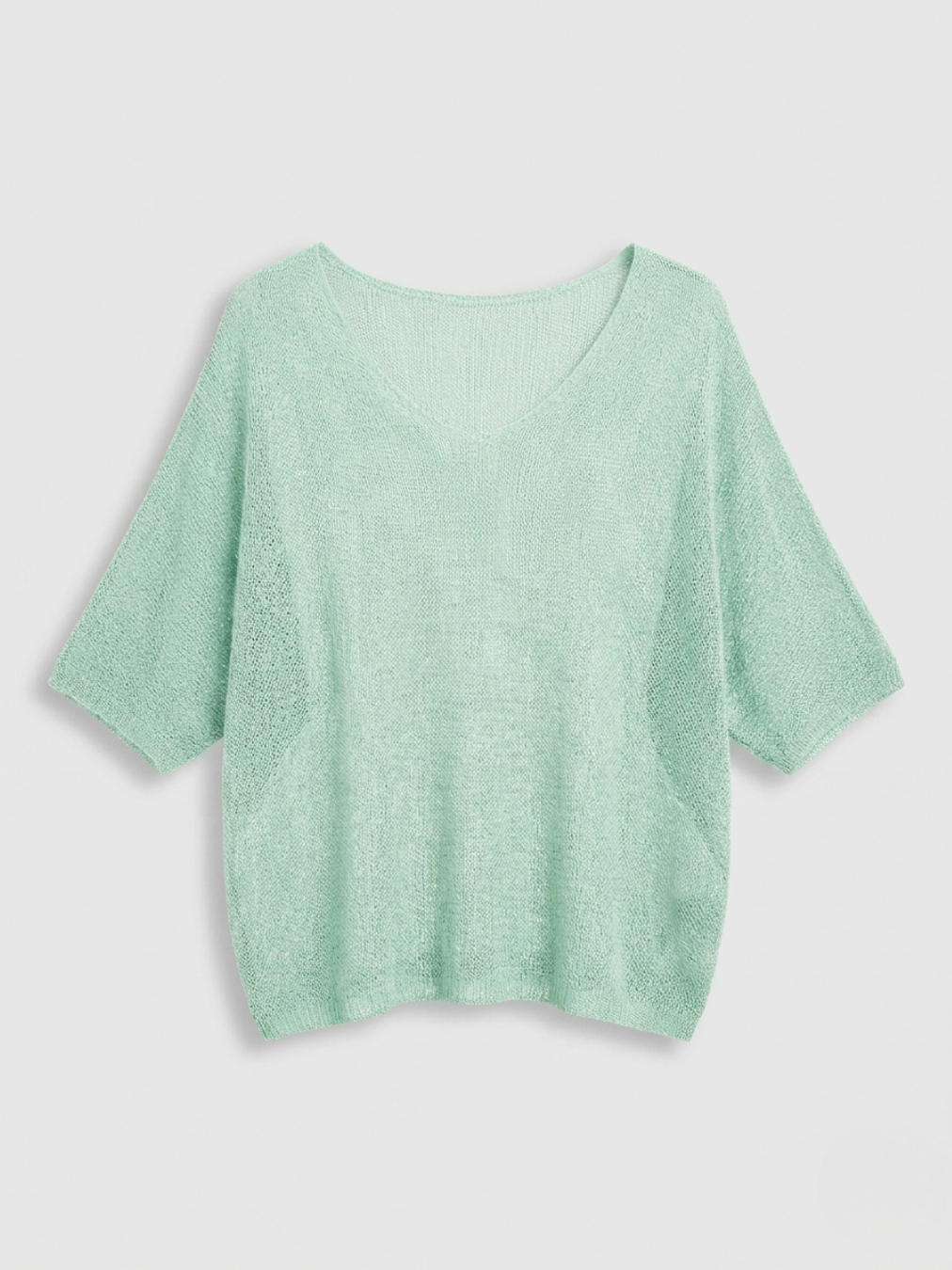 Jersey fino transparente color verde menta suave con diseño de punto abierto.