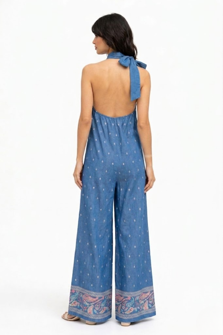 Vista trasera del mono denim mostrando la espalda descubierta y lazada al cuello.