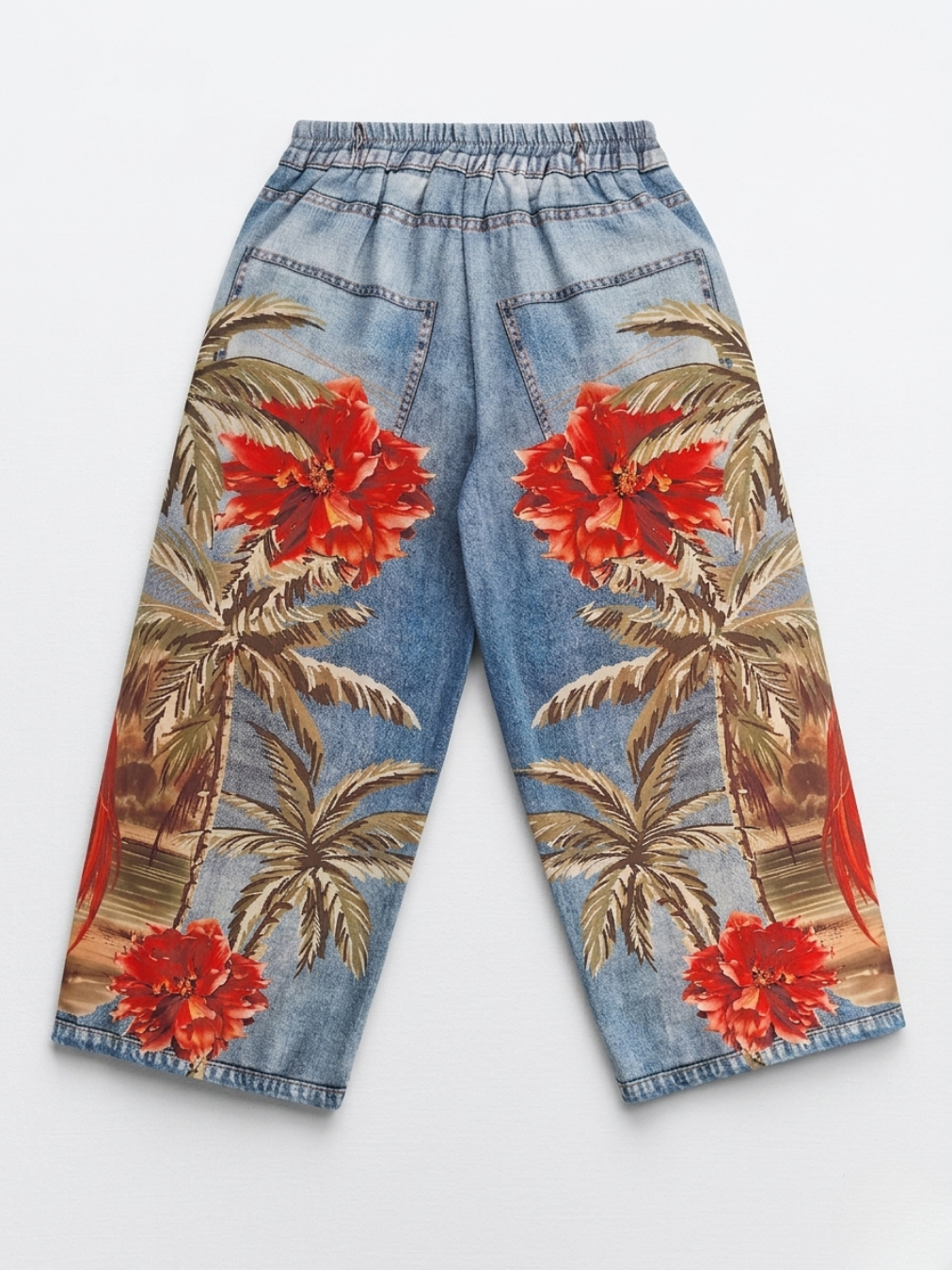 Parte posterior del pantalón con estampado de grandes flores rojas y paisaje de palmeras.