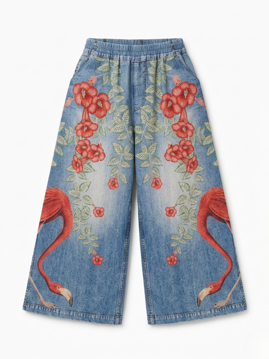Vista frontal del pantalón fluido efecto denim con estampado de flamencos y flores rojas.