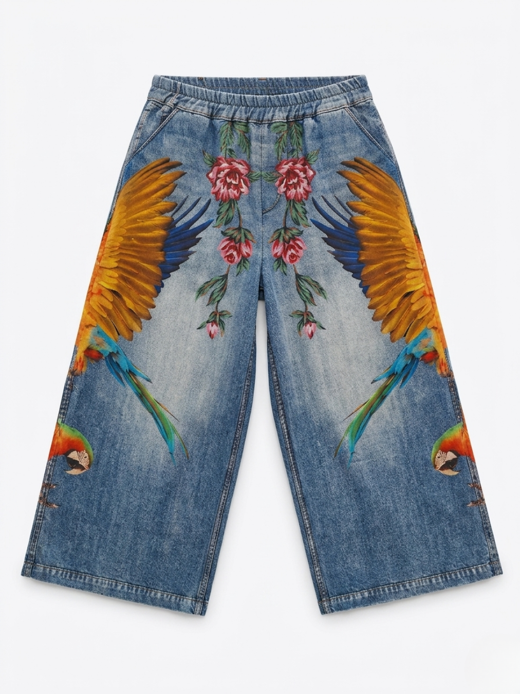 Vista delantera del pantalón con estampado realista de alas de guacamayo y flores rojas.