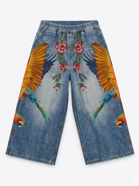 Vista delantera del pantalón con estampado realista de alas de guacamayo y flores rojas.