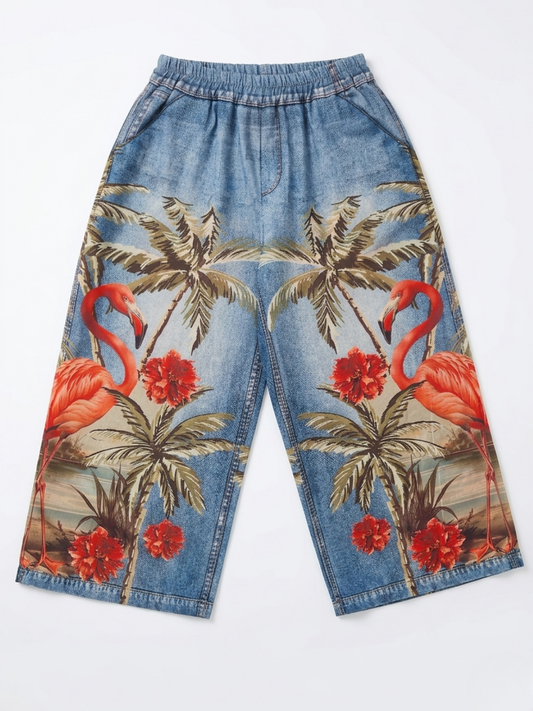 Vista delantera del pantalón efecto vaquero con estampado de palmeras y flamencos rosas.