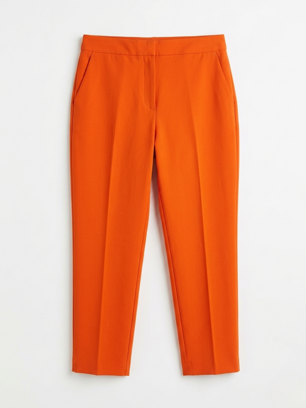 Pantalón sastre recto color naranja vibrante con pinzas delanteras marcadas y cierre limpio.