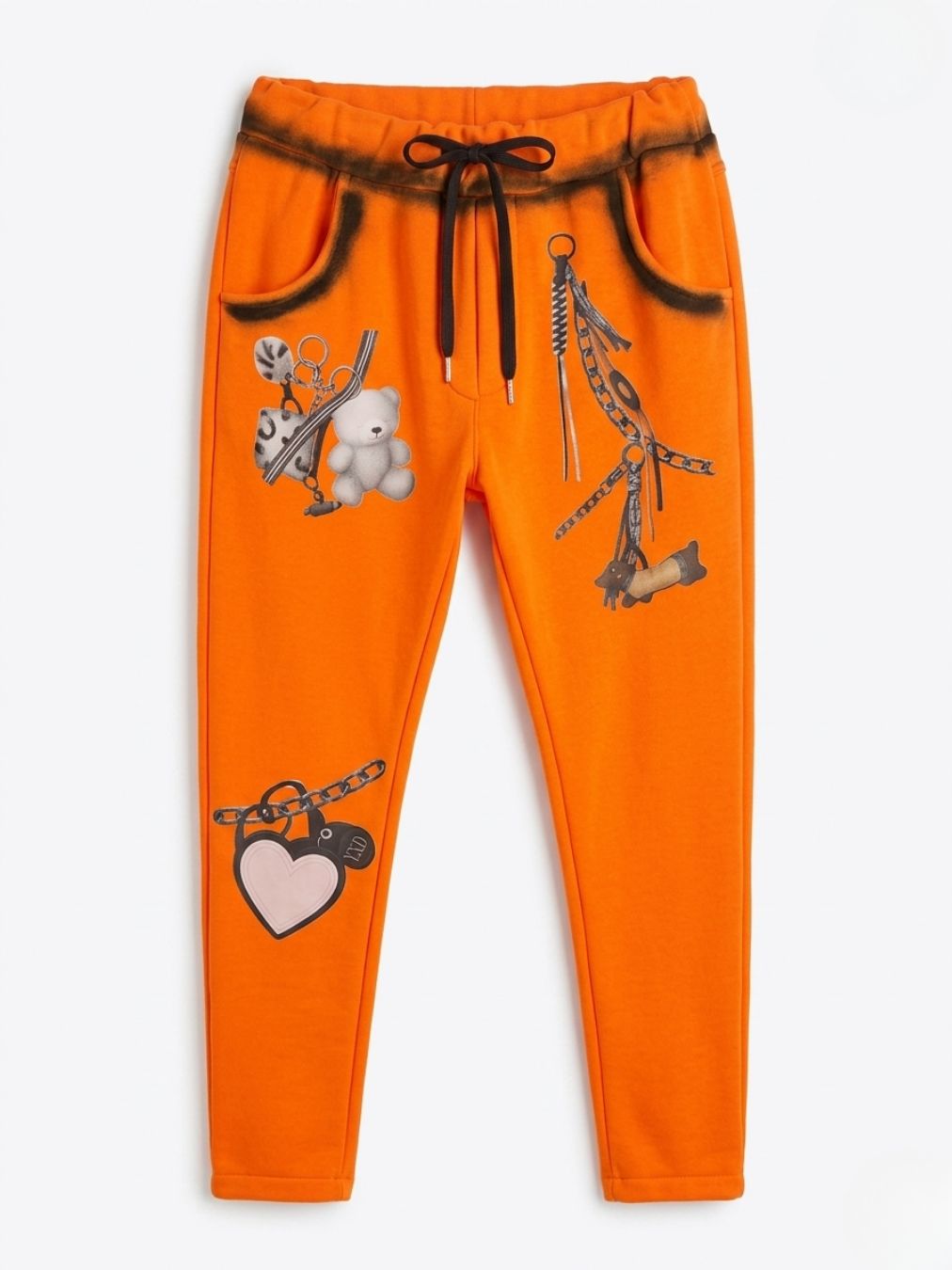 Vista delantera del pantalón ajustado naranja con cordón negro y estampados de osito y cadenas.