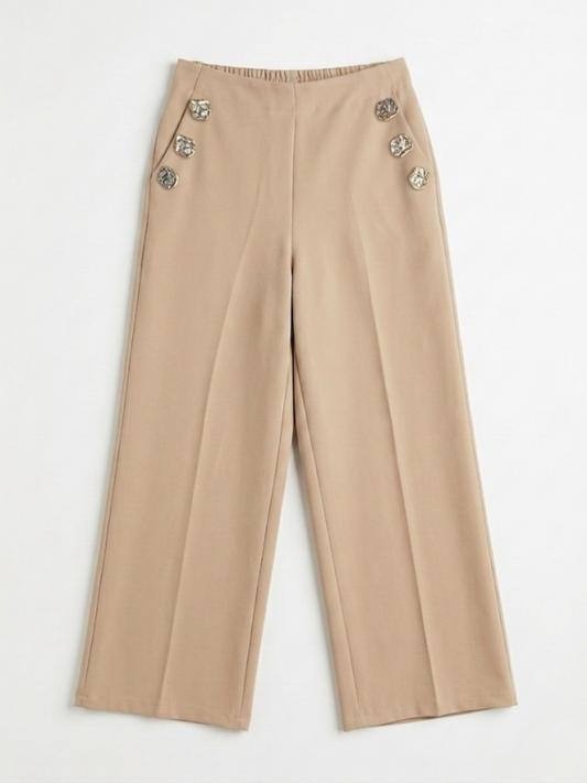 Vista frontal de pantalón fluido color beige de pernera ancha con botones metálicos laterales y bolsillos de Ángel Salvaje.