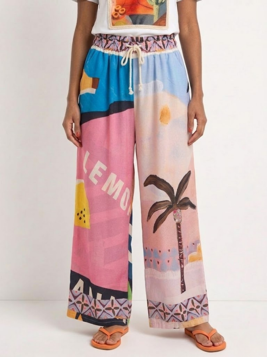 Vista frontal del pantalón ancho con estampado asimétrico de limones y palmeras en modelo.