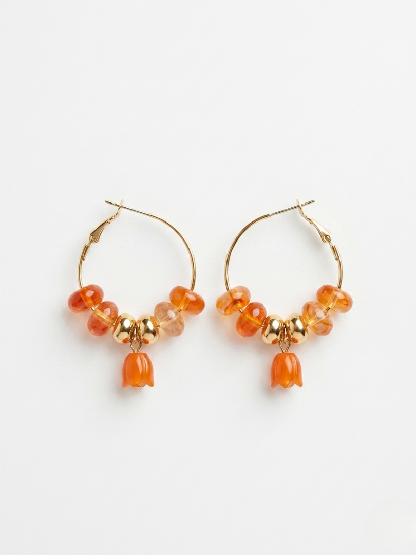 Pendientes de aro dorados con cuentas en color coral y detalle de colgante tulipán de la tienda Angel Salvaje.