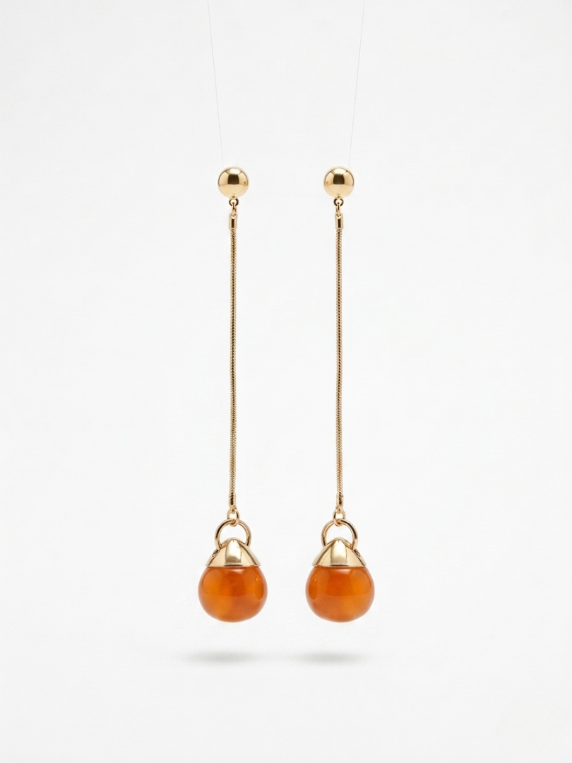 Pendientes de fiesta largos con piedra color ámbar y cadena fina dorada para looks elegantes.