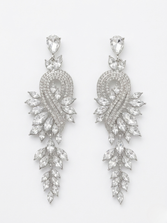 Pendientes de cristal blanco facetado con caída larga y acabado plata para looks de noche.