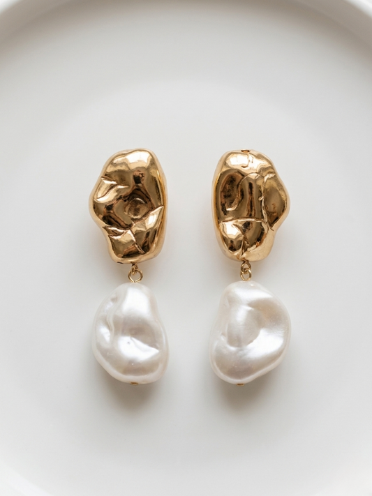 Pendientes largos dorados con textura orgánica y perla blanca grande de la tienda Angel Salvaje.