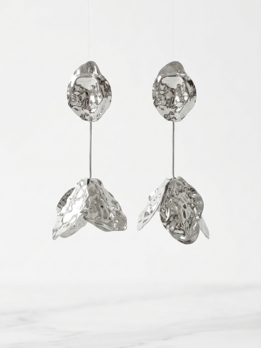 Pendientes plateados largos de diseño orgánico con textura martilleada y caída articulada de la tienda Angel Salvaje.