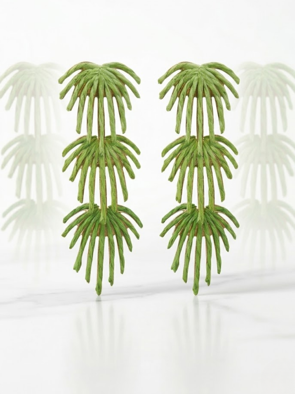 Primer plano de pendientes maxi colgantes en forma de cascada de tres niveles con diseño de hojas de palmera tropicales en color verde vibrante de Ángel Salvaje.