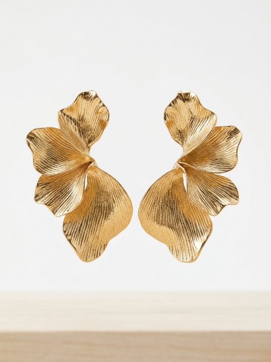Pendientes dorados grandes con forma de pétalos orgánicos y acabado con textura lineal de la tienda Angel Salvaje.
