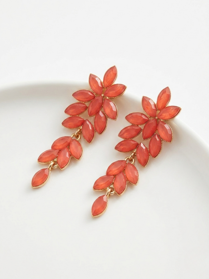 Pendientes largos color salmón con cristales en forma de rama para look de invitada.