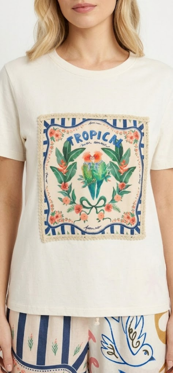 Detalle de la camiseta puesta mostrando el cuello redondo y el parche central decorativo.