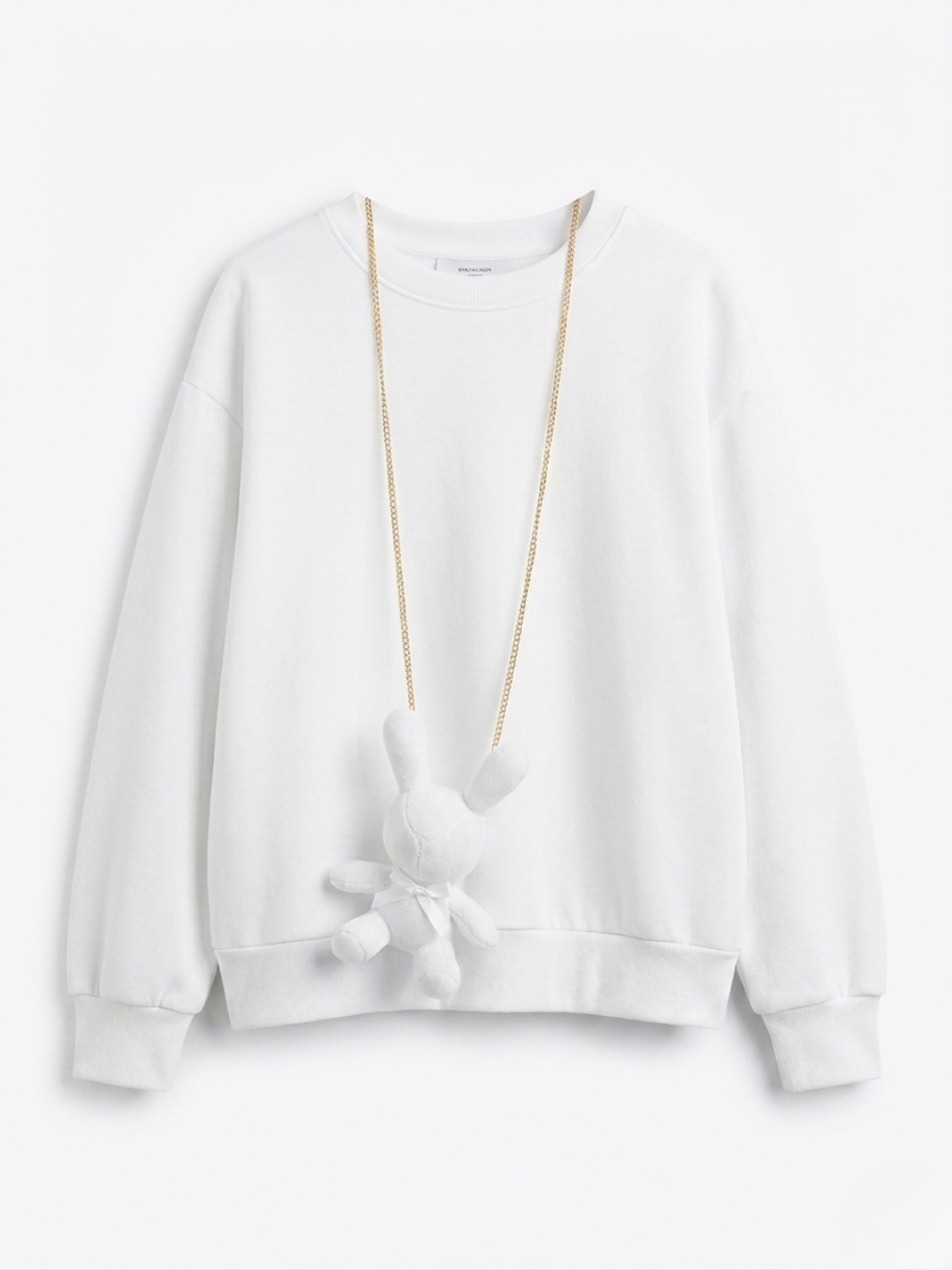 Sudadera blanca básica de talle relajado con accesorio de conejo de peluche blanco.