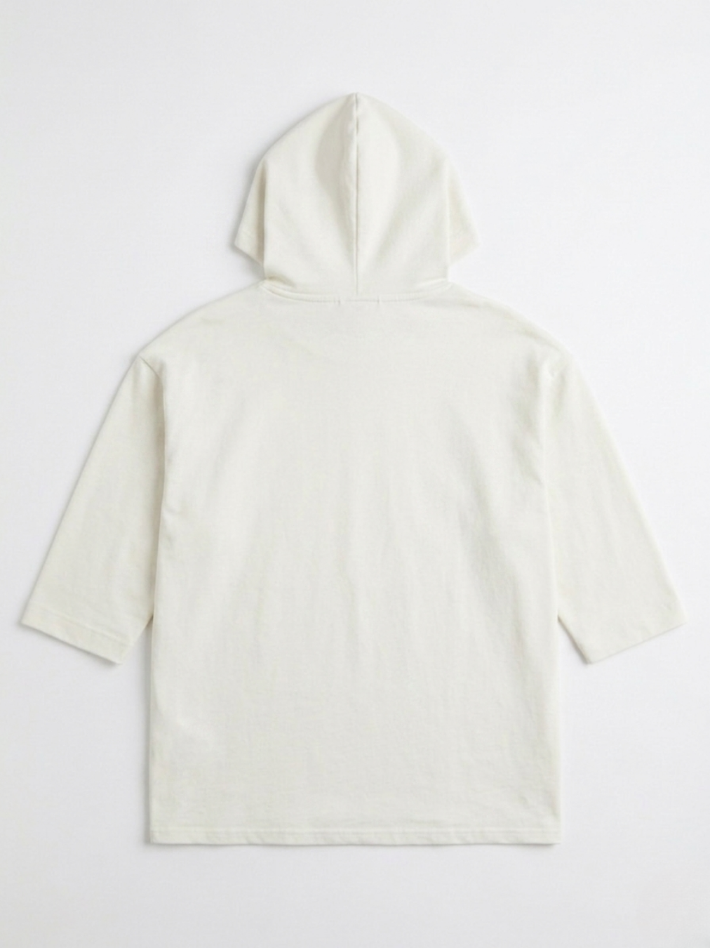 Parte posterior lisa de la sudadera oversize blanca con capucha resaltando el corte largo.