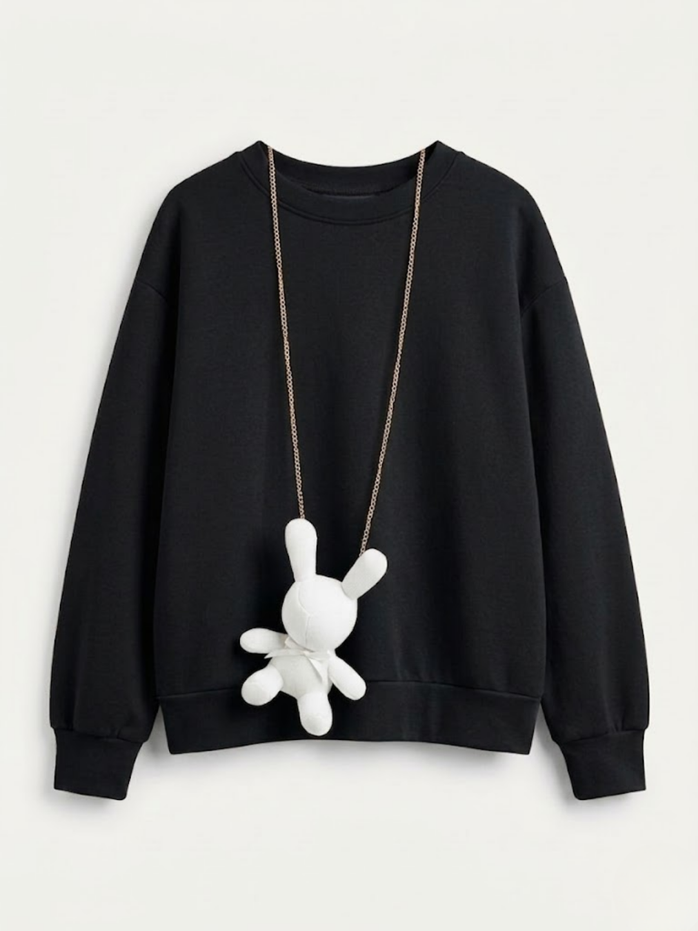 Sudadera negra de corte oversize con colgante de conejo de peluche blanco.