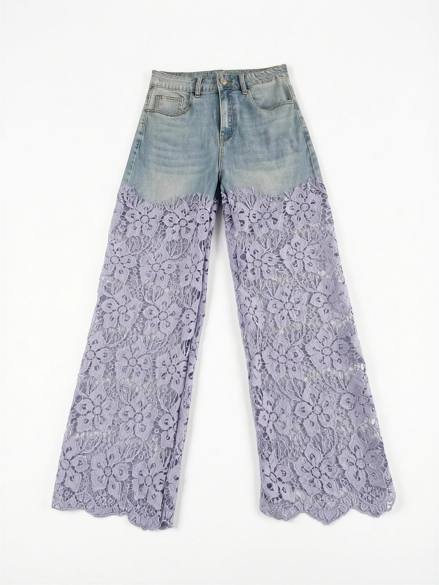 Vista frontal de pantalones vaqueros de tiro alto en mezclilla clara combinados desde el muslo con pernera ancha de encaje floral calado en color lila y bajo festoneado.