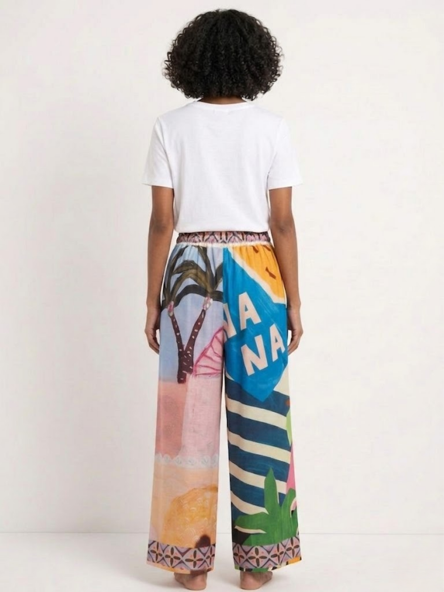 Modelo de espaldas mostrando el diseño "BANANA" y las rayas azules del pantalón fluido.